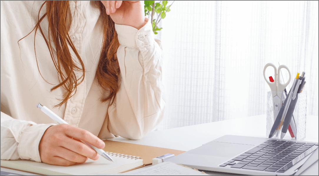 PCの前で勉強する髪の長い女性